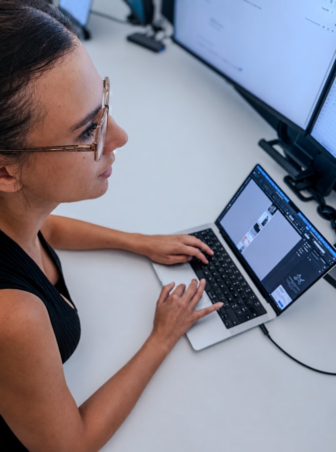 Person working on laptop surrounded by plants.